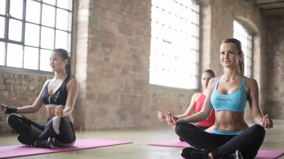 Yoga matı üzerinde esneme yapan kadınlar